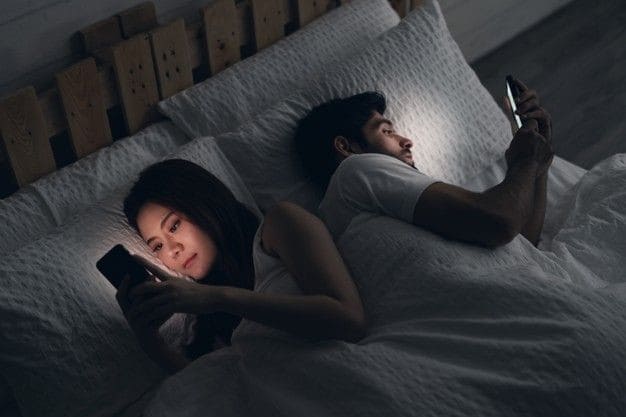 terapiapareja3 pareja con el teléfono en la cama